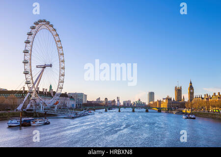 Londons Skyline Blick bei Sonnenaufgang mit berühmten Wahrzeichen, Big Ben, Houses of Parliament und Schiffe auf der Themse mit klaren blauen Himmel - England, UK Stockfoto