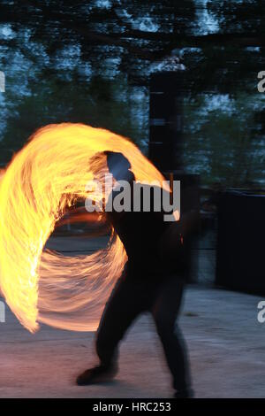 Feuer-Tänzerin mit Benzin (gelbe Flammen) und Feuerwerk (weiße Funken) Stockfoto