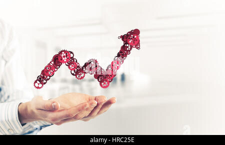 Schließen der Hände halten in Palmen wachsen Grafik gemacht von Zahnrädern Stockfoto