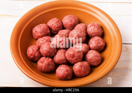 Rohe Frikadellen in Platte auf einem weißen Holztisch Hintergrund Stockfoto