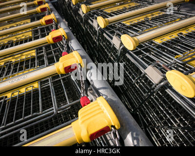 Einkaufswagen bleiben auf dem Parkplatz, Schließsystem auf der Münze. Stockfoto