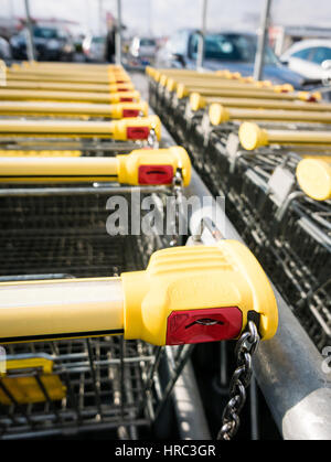 Einkaufswagen bleiben auf dem Parkplatz, Schließsystem auf der Münze. Stockfoto