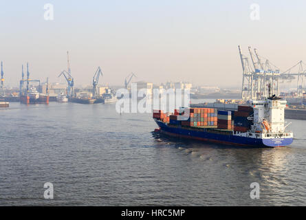 Hamburg, Deutschland - Februar 15, 2017: Teil des Hamburger Hafens mit einem Containerschiff in den Vordergrund und mehrere Docks und Hafen Krane in der ba Stockfoto