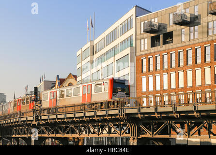 Hamburg, Deutschland - Februar 15, 2017: U-Bahn-Zug auf einer Brücke vor dem Gebäude in der Nähe der Station Baumwall. Stockfoto