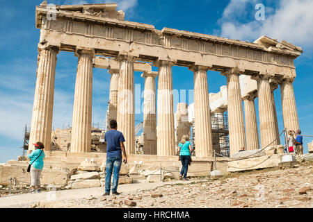 Touristen, die gerne an den antiken dorischen Säulen auf der Akropolis in Athen, Griechenland an einem sonnigen Sommertag Nahaufnahme der Ruinen Stockfoto