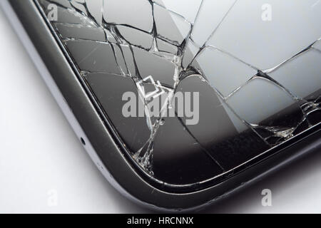 Nahaufnahme von einem gerissenen Smartphone-Bildschirm nach dem Fallenlassen auf den Boden. Konzept für defekte Telefone. Stockfoto