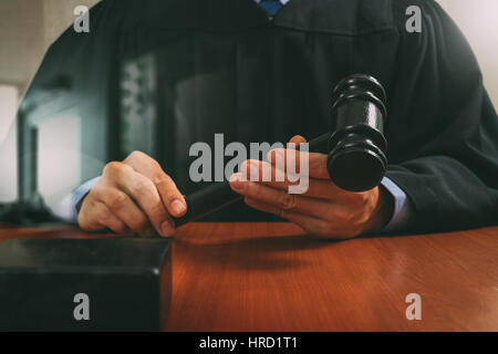 Recht und Gesetz-Konzept. Männlichen Richter in einem Gerichtssaal auffällig die Hammer, arbeiten mit digitalen Tablet Computer Docking-Tastatur auf Holztisch, Filter-Effekt Stockfoto