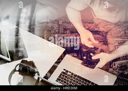 Doppelbelichtung von Hipster Hand mit Smartphone und Laptop Compter, Digital tablet Docking-Tastatur halten Cradit Karte Online-Zahlungsverkehr, sitt Stockfoto