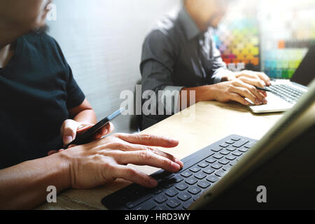 Coworking-Prozess, Unternehmer-Team arbeitet in kreativen Büroräume. Verwendung von digital-Tablette Docking-Tastatur und Laptop mit Smartphone auf Marmor Tisch, Stockfoto