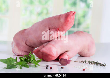 Rohes Schweinefleisch Beine mit Petersilie auf weißem Hintergrund Stockfoto