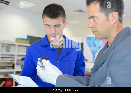 Arbeiter mit Lehrling Stockfoto