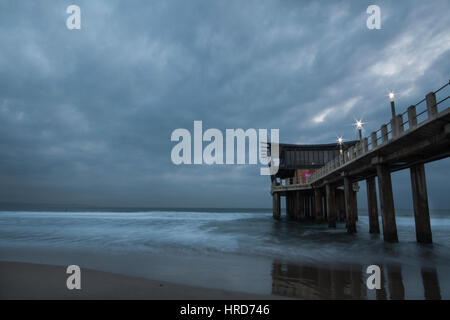 Der Pier am Addington Strand an einem bewölkten Morgen Stockfoto