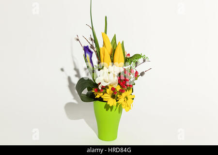 bunte Blumen Strauß Tulpen, Chrysanthemen, rote Hypericums und Iris in Vase isoliert auf weißem Hintergrund Stockfoto