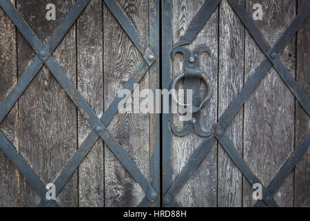 Eine alte Holztor ziert das geschmiedete Gitter Stockfoto