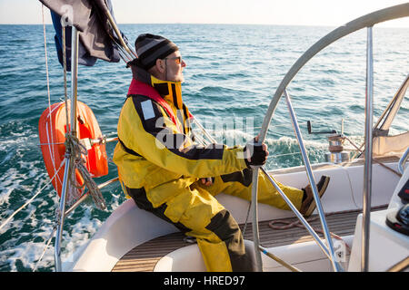 Seitenansicht des reifer Mann tragen Windjacke auf Segelboot im Meer Stockfoto