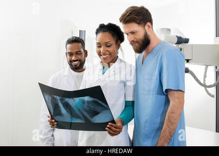 Männliche und weibliche Radiologen untersuchen Röntgen im Untersuchungsraum Stockfoto
