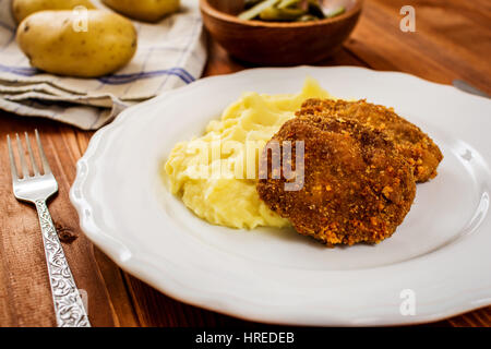 Gebratenes Hackfleisch mit Käse und Kartoffelpüree auf weißen Teller Stockfoto