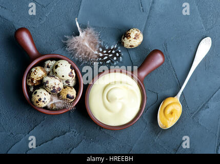 frische Mayonnaise-Sauce in Schüssel geben und auf einem Tisch Stockfoto