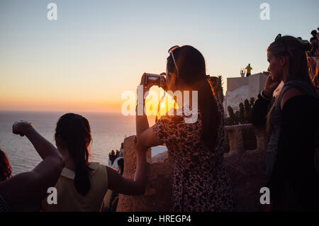 Touristen beobachten den Sonnenuntergang in schönen Santorini, Griechenland. Stockfoto