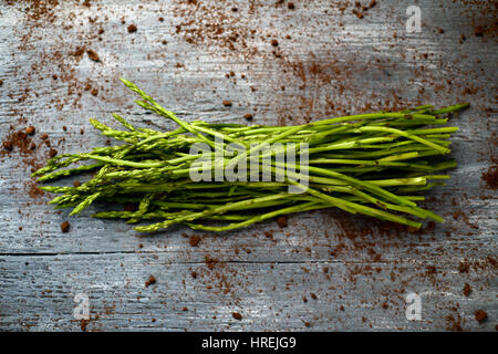 High-Angle Shot von einem Haufen wilder Spargel auf einer rustikalen Holzoberfläche Stockfoto