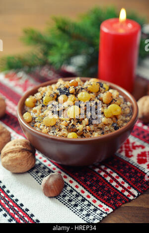 Traditionelle Weihnachten slawischen Gericht Kutia in Keramikschale mit Löffel und Kerze Stockfoto