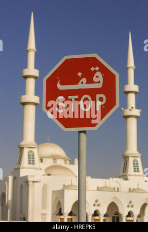 FUJAIRAH, Vereinigte Arabische Emirate - Stop-Schild auf Arabisch und Englisch, vor Moschee. Stockfoto