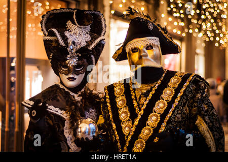 Atemberaubende Masken aus der Karneval von Venedig. Paar verkleidet in Kostümen. Der Mann mit dem goldenen bauta Maske. Stockfoto