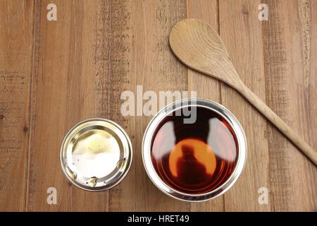 Draufsicht auf eine Dose mit Sirup, auf Holztisch mit Holzlöffel Stockfoto
