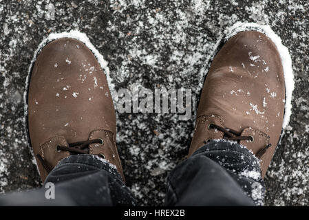 Braune Stiefel mit Schneeflocken, Ansicht von oben abgedeckt. Stockfoto