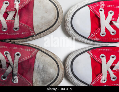 zwei Paare von alten und neuen roten Basketball Sneakers isoliert auf weißem Hintergrund Stockfoto