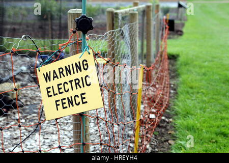 Warnschild Elektrozaun am Elektrozaun Stockfoto
