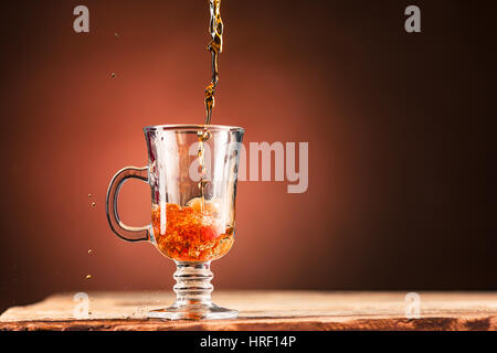 Braun Spritzer Getränk aus blauen Tasse Tee auf einem braunen Holz Hintergrund. Stockfoto