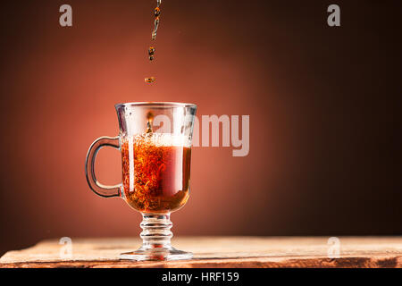 Braun Spritzer Getränk aus blauen Tasse Tee auf einem braunen Holz Hintergrund. Stockfoto