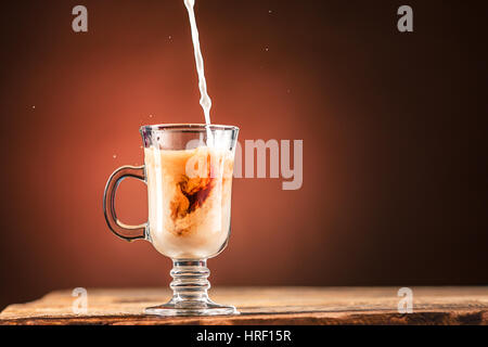 Braun Spritzer Getränk aus weißen Tasse Tee auf einem braunen Holz Hintergrund. Stockfoto