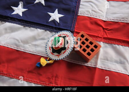 Lehmziegel und mexikanischen Sombrero auf USA-Flagge als Symbol für die verkündet "Trump-Mauer" Foto von Willy Matheisl Stockfoto