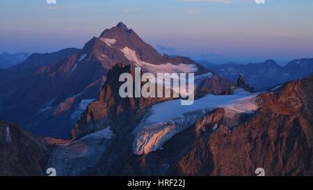 Sonnenuntergang-Szene in den Schweizer Alpen, lila Berge Fleckistock und Stucklistock. Stockfoto