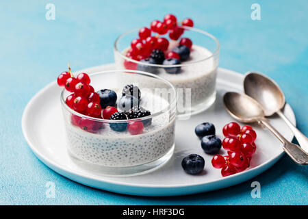 Chia Samen Pudding, Käsekuchen, Pudding Dessert mit frischen Beeren in eine Glasschüssel auf weißen Teller. Stockfoto