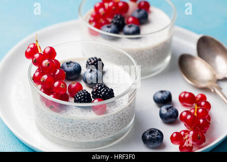 Chia Samen Pudding, Käsekuchen, Pudding Dessert mit frischen Beeren in eine Glasschüssel auf weißen Teller. Stockfoto