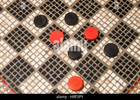 Rote und schwarze Dame auf einem schwarzen und weißen Checker Board mit Mosaik-Stücke aus Stein gemacht. Stockfoto