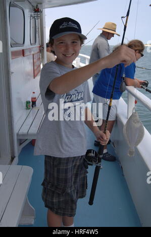 Fröhlicher Junge Kind fängt einen Fisch zu Angeln Partei Boot, Outer Banks, North Carolina Stockfoto