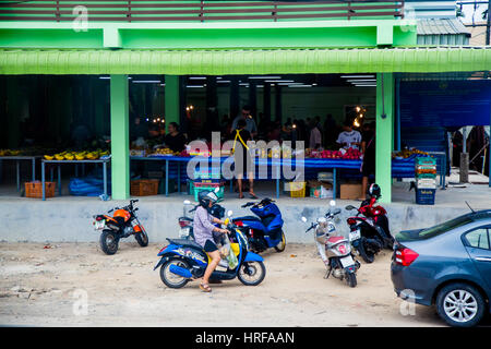 Thailand, Phuket - 19. Februar 2017: Straßenmarkt in Thailand. Käufer kommen auf dem Fahrrad Stockfoto