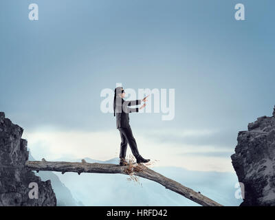 Geschäftsmann mit Blindfolder Augen gehen auf Holzscheit. Mixed-media Stockfoto