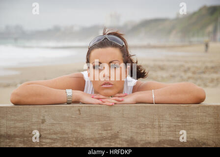 Schöne junge Frau am Strand mit einer weißen Weste Stockfoto
