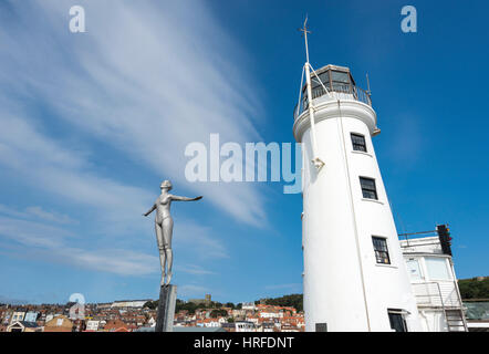 Tauchen Belle Statue neben dem Leuchtturm am Hafen von Scarborough, North Yorkshire, England. Stockfoto