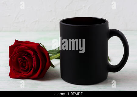 Schwarzer Kaffee Becher Mockup mit roter Rose. Leere Becher mock up für Markenwerbung. Stockfoto