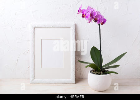 Weißer Rahmen Mockup mit lila Orchidee im Blumentopf. Leere Rahmen mock up für Präsentationsdesign. Stockfoto