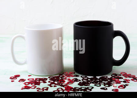 Weiße und schwarze Becher Mockup mit Apfelblüte.  Leere Becher mock up für Markenwerbung. Stockfoto