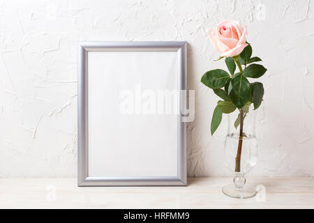 Silberrahmen Mockup mit weichen rosa Rose in exquisiten Vase. Leere Rahmen mock für Präsentation Kunstwerk. Stockfoto