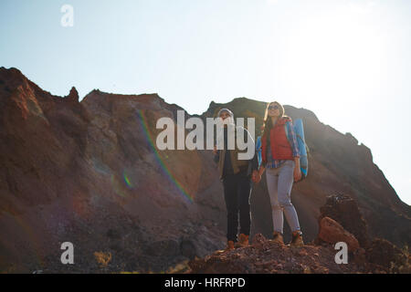 Sonnigen Bild der jungen Paar, Mann und Frau, Blick in die Berge, Hügel, Hand in Hand Reisen Stockfoto