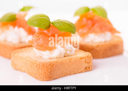 Canapes mit Räucherlachs, Frischkäse und Basilikum Stockfoto